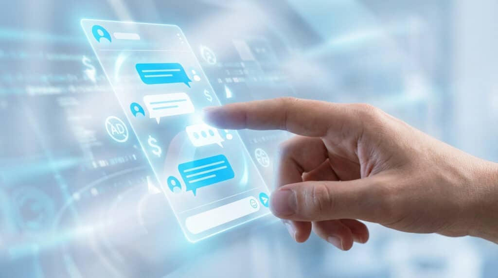 A hand touches a glowing holographic chat interface displaying white messages, blue symbols for ads/currency, within a futuristic blue and white digital space.