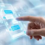 A hand touches a glowing holographic chat interface displaying white messages, blue symbols for ads/currency, within a futuristic blue and white digital space.