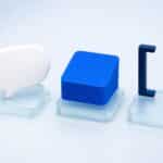 Trois objets 3D abstraits sur des socles : bulle de dialogue blanche, pile de feuilles bleue et cadre bleu nuit, illustrant les modes Chat, Work et Codex de ChatGPT