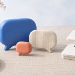 Illustration chatbot design : bulles de conversation en trois matières et cartes de flux reliées sur une table de conception