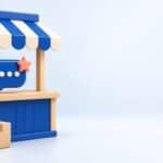 Illustration 3D d’une boutique en ligne avec auvent bleu et une bulle de chat posée sur le comptoir, symbole d’un chatbot PrestaShop